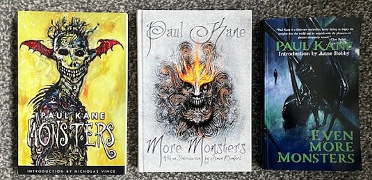 image showing three books on a grey surface. L to R: Monsters by Paul Kane, More Monsters by Paul Kane, and Even More Monsters by Paul Kane