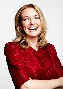 photograph of a laughing Angela Clarke, wearing a red top