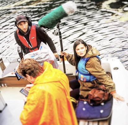 Woman and two men on boat, woman holding boom mic