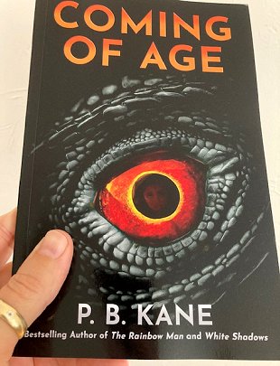 Hand holding a book: Coming of Age by P B Kane