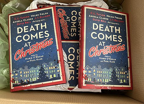 photograph showing an open cardboard box containing multiple copies of Death Comes at Christmas, edited by Marie O'Regan and Paul Kane