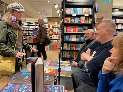 a young woman chatting to authors Tom Mead, Russ Thomas and Marie O'Regan