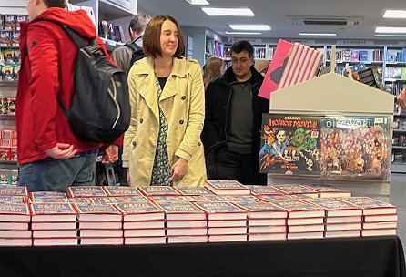 photograph of people queuing to get their copies of Death Comes at Christmas, edited by Marie O'Regan and Paul Kane. A table filled with copies of the anthology is in the foreground