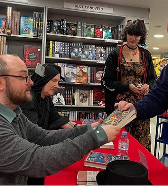 Tom Mead signing books for customers at Forbidden Planet. Behind him is Russ Thomas, dressed as Death