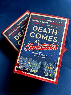 photograph of two copies of Death Comes at Christmas, edited by Marie O'Regan and Paul Kane, on a blue background