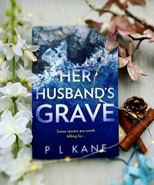 Book display - flowers, fairylights, cinamon, pinecone, book cover: Her Husband's Grave by P L Kane
