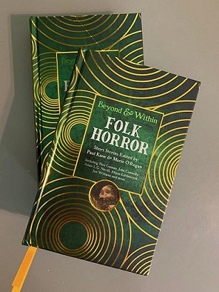 photograph of two copies of Beyond & Within Folk Horror, edited by Paul Kane and Marie O'Regan, against a plain grey background