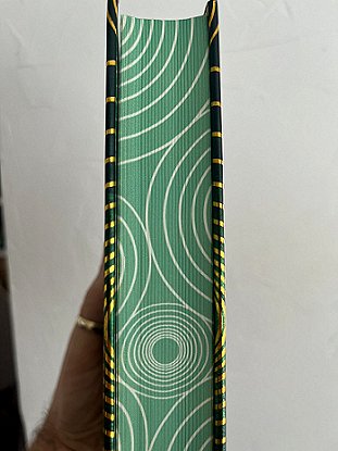 image showing the sprayed edges of Beyond and Within Folk Horror, edited by Paul Kane and Marie O'Regan. Page edges are sprayed green, with a pattern of repeated gold concentric circles