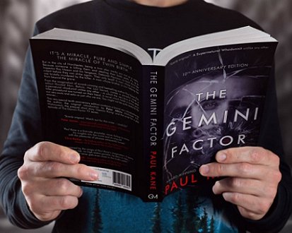 Man holding copy of The Gemini Factor (10th Anniversary edition) by Paul Kane