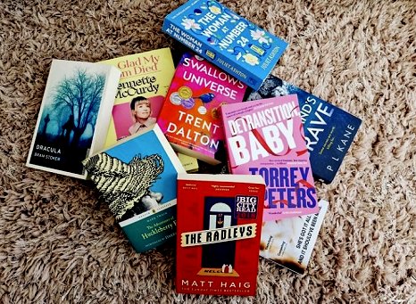 image of books scattered on carpet, including Her Husband's Grave by P L Kane