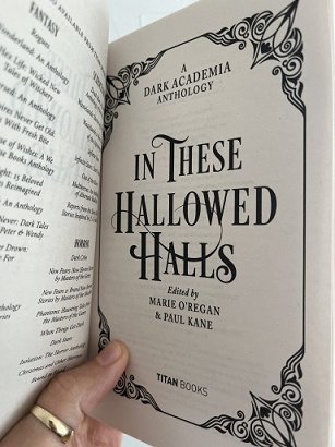 photograph showing the title page of the paperback version of In These Hallowed Halls, edited by Marie O'Regan and Paul Kane