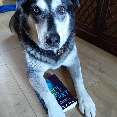 Starsky the dog with copy of Her Last Secret by P.L. Kane