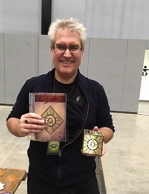 Photograph of a smiling Paul Kane holding a Scribe Box, which he designed