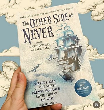 image of a hand holding a copy of The Other Side of Never, edited by Marie O'Regan and Paul Kane, against a blue background decorated with white clouds