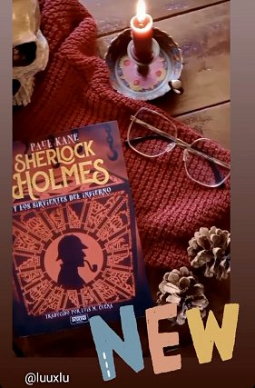 display showing a copy of the Spanish edition of Sherlock Holmes and the Servants of Hell by Paul Kane, lying on a red knitted cloth, alongside two pine cones and a pair of glasses. Text reads NEW