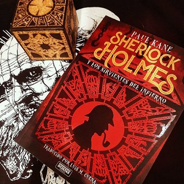 photograph showing a copy of the Spanish edition of Sherlock Homes and the Servants of Hell by Paul Kane on a black and whilte image of Pinhead, next to a puzzle box