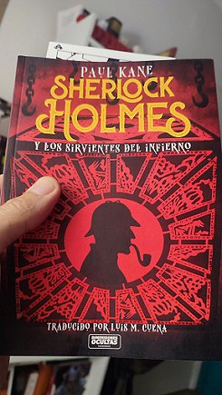 Photograph of someone holding a copy of the Spanish edition of Sherlock Holmes and the Servants of Hell by Paul Kane