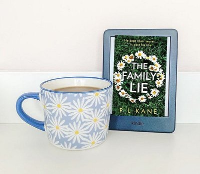 Kindle showing copy of The Family Lie by P L Kane and a cup patterned with daisies