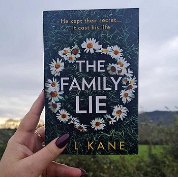 Woman's hand holding a copy of The Family Lie by P L Kane