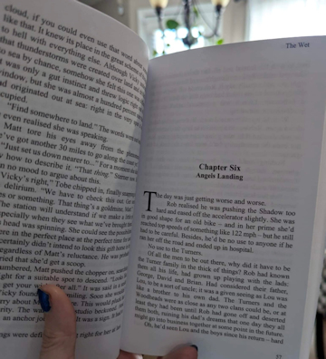 photograph of a hand holding a copy of The Wet by Paul Kane open to Chapter Six - Angels Landing