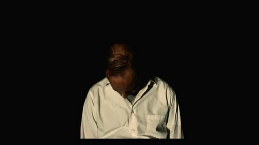 Still from The Torturer, man sitting with head bowed