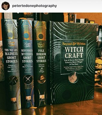 photograph showing a copy of Beyond and Within Witchcraft, edited by Marie O'Regan and Paul Kane, standing beside copies of This Way Lies Madness short stories, Midsummer Mysteries short stories, and Folk Horror short stories