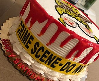 Birthday cake decorated with Crime Scene tape and blood coloured icing