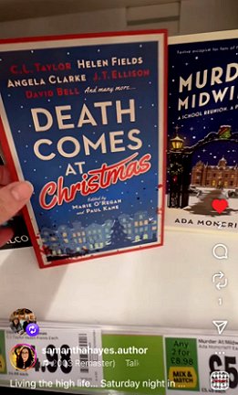 photograph of a hand holding a copy of Death Comes at Christmas, edited by Marie O'Regan and Paul Kane, against a bookshelf