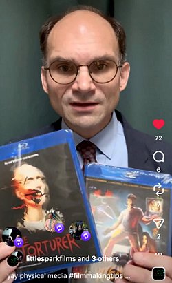 photograph of Preston Fassell, Creative Director and Head of Development for Little Spark Films, holding up a blu-ray of The Torturer, written by Paul Kane